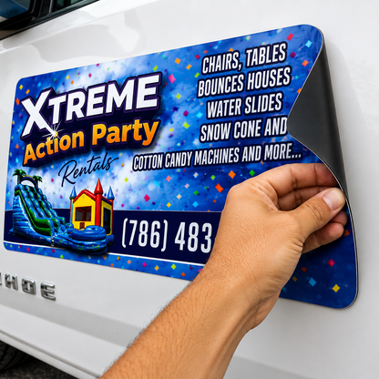 Hand applying a colorful advertisement for Xtreme Action Party Rentals on a car window.